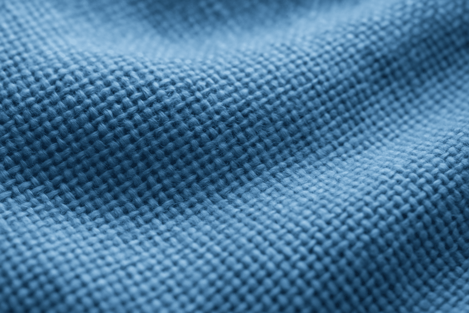 Detailed close-up of blue cotton fabric weave pattern showing thread interlacing and texture