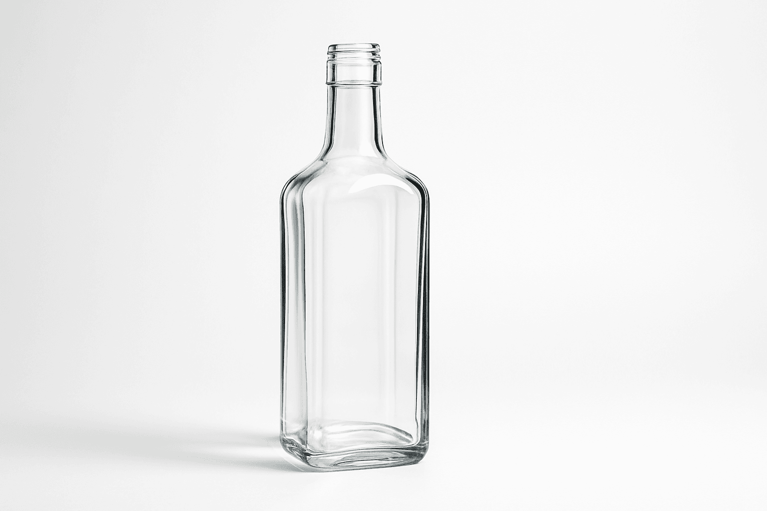 Close-up view of a transparent glass bottle with natural reflection effects and subtle lighting on a clean background