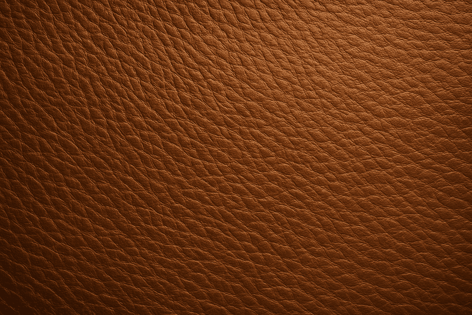 Close-up detailed leather grain texture showing natural irregular patterns under warm lighting