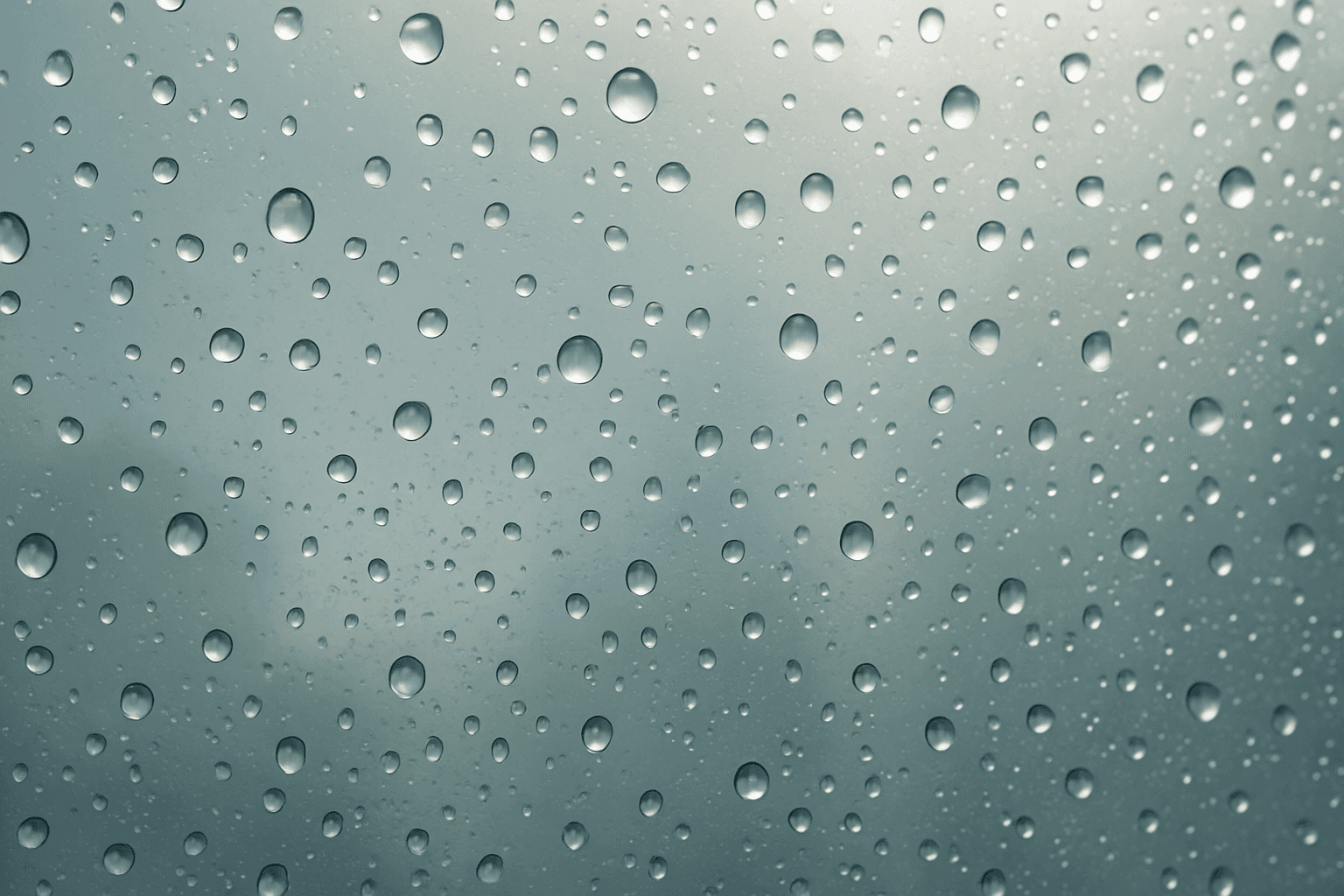 Close-up of glass surface covered with realistic wet droplets and glistening reflections
