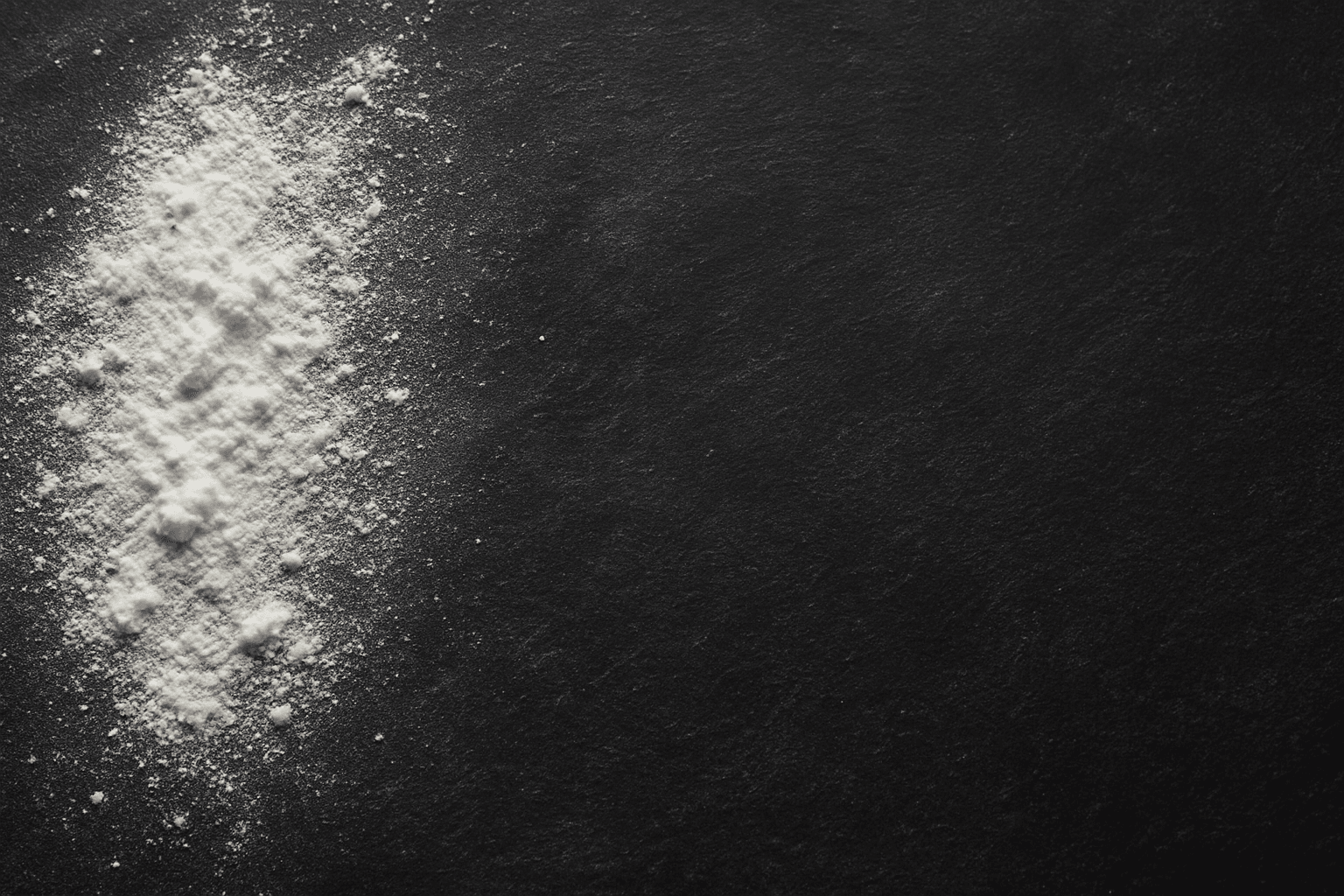 Close-up of chalk texture background with powdery and grainy white chalk markings on blackboard surface