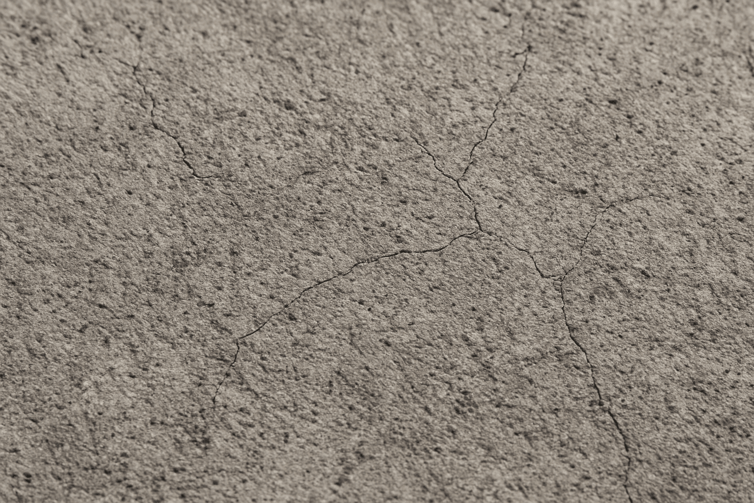 Close-up of detailed rough concrete texture surface with visible cracks and natural gray tone