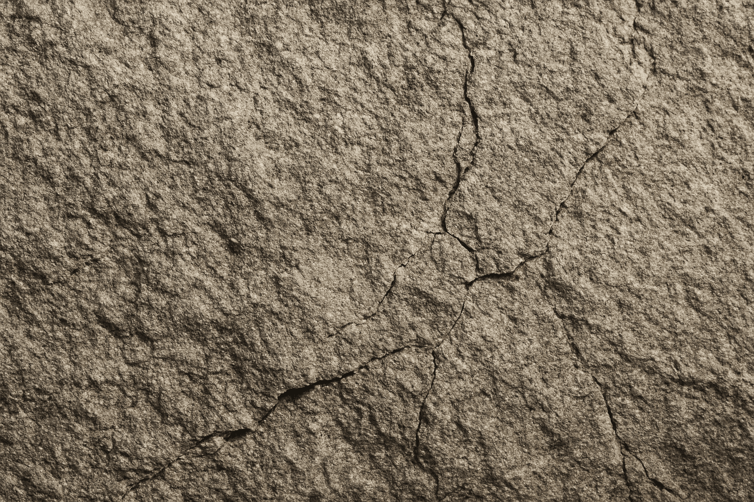 Close-up of rough stone texture showing grains and cracks with natural lighting