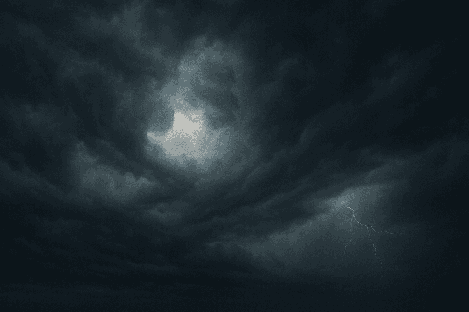 Dark tense stormy sky with heavy swirling clouds and diffused lighting over a landscape